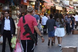 Young Israelis carry their personal rifles at the Jerusalem …