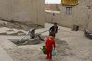 An Afghan child carries water from a well in Kabul on April 22, 2013