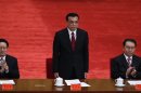 In this May 4, 2012 photo, Chinese vice Premier Li Keqiang, center, stands up while Zhou Yongkang, left, and Li Changchun, right, both Communist Party Politburo Standing Committee members, clap at a conference to celebrate the 90th anniversary of the founding of Chinese Communist Youth League at the Great Hall of the People in Beijing, China. Xi Jinping, China's vice president, has not been seen in public since Sept. 1, fueling speculation that he suffered a health crisis that forced him to cancel meetings with Hillary Clinton and others. Much attention will likely turn to Executive Vice Premier Li Keqiang, who many had picked as Hu Jintao's preferred successor before Xi emerged in late 2007 as a choice more acceptable to the party's factions. (AP Photo/Alexander F. Yuan)