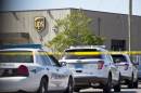 A UPS warehouse has police cars and tape surrounding it on Tuesday, Sept. 23, 2014, in Birmingham, Ala. A UPS employee opened fire Tuesday morning inside one of the company's warehouses in Alabama, killing two people before taking his own life, police said.(AP Photo/Brynn Anderson)