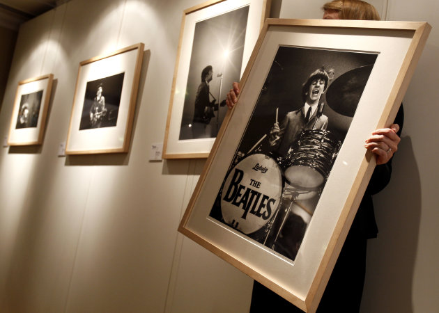 A Christie's employee hangs Mike Mitchell's photograph of The Beatles where his collection is being exhibited at a hotel in London, Friday, June 10, 2011. The previously unseen photographs by US photo