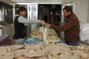 A customer buys bread at a bakery in Baghdad