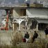 Local residents watch as authorities use heavy machinery to demolish the compound of Osama bin Laden in Abbottabad, Pakistan on Sunday, Feb. 26, 2012. Pakistan was more than halfway done Sunday demolishing the three-story compound where bin Laden was killed by U.S. commandos last May, erasing a concrete reminder of a painful and embarrassing chapter in the country's history.   (AP Photo/Anjum Naveed)