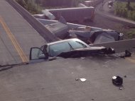 A car lies in-between damaged sections of a highway overpass near Rockview, Mo. on Saturday, May 25, 2013. Authorities said the roadway collapsed when rail cars slammed into one of the bridge's pillars after a cargo train collision. Seven people were injured, though none seriously. (AP Photo/KFVS, Michael Mohundro)