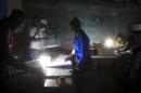 Electoral workers organize materials at a polling station lit with lamps at the start of elections in Port-au-Prince, Haiti, Sunday, Nov. 20, 2016. Haiti's repeatedly derailed presidential election got underway more than a year after an initial vote was annulled. (AP Photo/Dieu Nalio Chery)