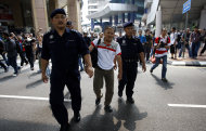 Malaysian police officers detain a man near Independence Square in Kuala Lumpur, Malaysia, Saturday, July 9, 2011. Malaysian police said they have detained at least 236 people trying to assemble at a stadium for a banned rally seeking electoral reforms. (AP Photo/Lai Seng Sin)