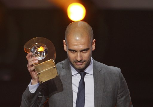 FIFA World Coach of the Year for Men?s Football award winner Guardiola of Spain holds his FIFA Ballon d'Or 2011 trophy during the FIFA Ballon d'Or 2011 soccer awards ceremony in Zurich