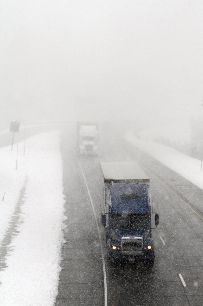 Trucks drive along the fog and snow shrouded Interstate 80 near Soda Springs, Calif., Wednesday, Oct. 5, 2011.  An early October storm swept through Northern California bringing rain to the lower levels and up to six inches of snow to the Sierra Nevada.(AP Photo/Rich Pedroncelli)