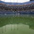 Water gathers on the court at Arthur Ashe Stadium during the U.S. Open tennis tournament in New York, Tuesday, Sept. 6, 2011. The start of play at the U.S. Open is being delayed because of rain. (AP Photo/Mel Evans)