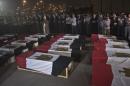 Egyptian army and security officers pray over coffins at Almaza military Airbase in Cairo on August 19, 2013, during the funeral of the 25 policemen killed in North Sinai