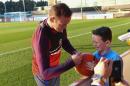 England's striker Wayne Rooney signs an autograph for a young fan after a training session at England's training facility at St George's Park in Burton-upon-Trent, on October 4, 2016