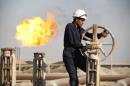 File photo of a worker adjusting the valve of an oil pipe at West Qurna oilfield in Iraq's southern province of Basra