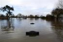 Gravestones are partially submerged in water in the flooded Somerset village of Moorland