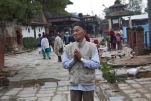 A Nepalese elderly man prays next to a building damaged &hellip;