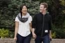 File photo of Facebook CEO Zuckerberg walking with wife Priscilla Chan