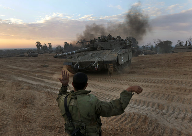 An Israeli soldier guides a tank to a new position at a staging area near the Israel Gaza Strip Border, southern Israel, Thursday, Nov. 22, 2012. A cease-fire agreement between Israel and the Gaza Strip's Hamas rulers took effect Wednesday night, bringing an end to eight days of the fiercest fighting in years and possibly signaling a new era of relations between the bitter enemies. (AP Photo/Lefteris Pitarakis)