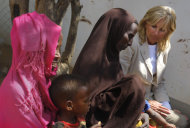 In this photograph taken during an official White House organized visit, Jill Biden, wife of U.S. Vice President Joe Biden, sits with Somali refugees during a photo opportunity at a UNHCR screening center on the outskirts of Ifo camp outside Dadaab, eastern Kenya, 100 kms (60 miles) from the Somali border, Monday Aug. 8, 2011. (AP Photo/Jerome Delay)