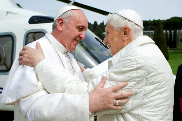 In this photo provided by the Vatican paper L'Osservatore Romano, Pope Francis meets Pope emeritus Benedict XVI in Castel Gandolfo Saturday, March 23, 2013. Pope Francis has traveled to Castel Gandolfo to have lunch with his predecessor Benedict XVI in a historic and potentially problematic melding of the papacies that has never before confronted the Catholic Church. The Vatican said the two popes embraced on the helipad. In the chapel where they prayed together, Benedict offered Francis the traditional kneeler used by the pope. Francis refused to take it alone, saying "We're brothers," and the two prayed together on the same one. (AP Photo/Osservatore Romano, HO)