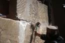Image grab from video made available by Jihadist media outlet Welayat Nineveh on April 11, 2015, allegedly shows members of the Islamic State destroying a stoneslab with a sledgehammer at what they said was ancient Assyrian city of Nimrud, Iraq