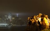 Tourists photograph the skyline of New York as the "Tribute in Lights" is illuminated over Lower Manhattan during events marking the 10th anniversary of the 9/11 attacks on the World Trade Center, seen from Weehawken, New Jersey, September 11, 2011. REUTERS/Gary Hershorn