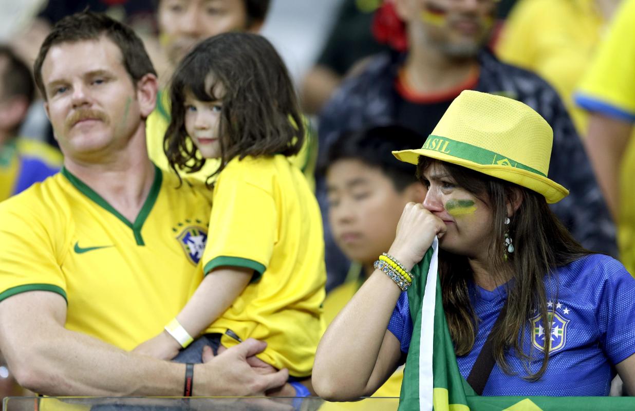 Brazil supporters react after Germany defeated Brazil 7-1 to advance to the finals during the World Cup semifinal soccer match between Brazil and Germany at the Mineirao Stadium in Belo Horizonte, Brazil, Tuesday, July 8, 2014. (AP Photo/Andre Penner)