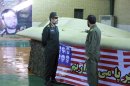 FILE - This file photo released on Thursday, Dec. 8, 2011, by the Iranian Revolutionary Guards, claims to show the chief of the aerospace division of Iran's Revolutionary Guards, Gen. Amir Ali Hajizadeh, left, listening to an unidentified colonel as he points to US RQ-170 Sentinel drone which Tehran says its forces downed earlier this week. (AP Photo/Sepahnews, File) EDS NOTE: THE ASSOCIATED PRESS HAS NO WAY OF INDEPENDENTLY VERIFYING THE CONTENT, LOCATION OR DATE OF THIS IMAGE.