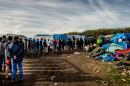 Migrants line up for food distribution in the "Jungle" camp in the northern French city of Calais on October 29, 2015