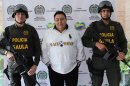 In this photo released by Colombia's National Police, police officers flank alleged Italian drug trafficker Roberto Pannunzi at a police station in Bogota, Colombia, Saturday, July 6, 2013. The fugitive Italian organized crime boss who prosecutors allege arranged monthly shipments of tons of South American cocaine to Europe and was one of the world's most powerful drug brokers, has been captured in Bogota in a shopping mall, Italian and Colombian authorities said Saturday. (AP Photo/Colombia's National Police)