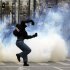 A protester throws a stone toward riot police during clashes in Athens, Friday, Feb. 10, 2012. Thousands took to the streets of Athens as unions launched a two-day general strike against planned austerity measures on Friday, a day after Greece's crucial international bailout was put in limbo by its partners in the 17-nation eurozone.  (AP Photo/Petros Giannakouris)