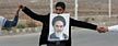 An Iranian student holds a poster of late revolutionary founder Ayatollah Khomeini with his mouth, near the Isfahan Uranium Conversion Facility. (AP Photo/Vahid Salemi)