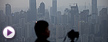 In this Tuesday April 3, 2012 photo, a photographer waits at a viewpoint to take photos of the city skyline at dusk in Chongqing city, southwestern China. Many residents of the Chinese city of Chongqing say they still admire their former leader Bo Xilai despite his dismissal in the biggest political scandal in years. (AP Photo/Alexander F. Yuan)