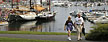 In this photo made Friday, Aug. 31, 2012, a couple strolls through a park by the harbor in Camden, Maine. The small coastal town is often cited in lists of best retirement places to move for people interested in cooler climates. (AP Photo/Robert F. Bukaty)