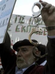 A protester holds handcuffs during an anti-government demonstration staged by civil servants outside the Greek Parliament in Athens, Tuesday, April 27, 2010. Greece's debt crisis intensified Tuesday as its credit rating cut to junk status. (AP Photo/Marita Pappa)