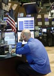 A Specialist holds his head as he works his post on the trading floor of the New York Stock Exchange Tuesday, May 4, 2010, in New York. Stocks plunged around the world Tuesday as fears spread that Europe's attempt to contain Greece's debt crisis would fail. (AP Photo/David Karp)