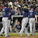 Tampa Bay Ray' James Loney, center right, is greeted at home plate by Matt Joyce after hitting a three-run home run off of New York Yankees relief pitcher Adam Warren that scored Joyce and Wil Myers (9) in the seventh inning of a baseball game at Yankee Stadium on Friday, July 26, 2013, in New York. (AP Photo/Kathy Kmonicek)