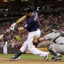 Minnesota Twins' Joe Mauer (7) hits an RBI single against Cleveland Indians relief pitcher Scott Maine as Indians catcher Lou Marson looks on during the seventh inning of a baseball game, Monday, Sept. 10, 2012, in Minneapolis. The Twins won 7-2. (AP Photo/Genevieve Ross)