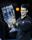 Serbia's Novak Djokovic holds the trophy after being ranked World number one, after the singles ATP World Tour Finals tennis match against Czech Republic's Tomas Berdych, at the O2 Arena in London, Friday, Nov. 14, 2014. (AP Photo/Kirsty Wigglesworth)