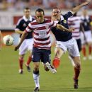 United States' Landon Donovan (10) is tripped up by Scotland's Scott Brown, right, during the first half of an exhibition soccer match, Saturday, May 26, 2012, in Jacksonville, Fla. United States won 5-1. (AP Photo/The Florida Times-Union, Will Dickey)