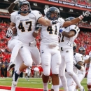 Kent State's Mark Fackler (47) celebrates his interception return for a touchdown with teammates Zack Hitchens (41) and Evan Shimensky (11) during the first half against Rutgers in an NCAA college football game in Piscataway, N.J., Saturday, Oct. 27, 2012. (AP Photo/Rich Schultz)