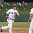 Texas Rangers Josh Hamilton rounds the bases past  third base coach Dave Anderson (16) after hitting a solo home run in the second inning of a baseball game against the Toronto Blue Jays Friday, May 25, 2012, in Arlington, Texas. (AP Photo/LM Otero)