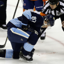 Pittsburgh Penguins center Sidney Crosby (87) is helped by referee Ian Walsh (29) after being hit in the face with a puck during the first period of an NHL hockey game against the New York Islanders in Pittsburgh, Saturday, March 30, 2013. Crosby left the game. (AP Photo/Gene J. Puskar)