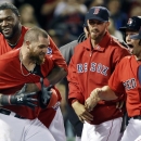 Boston Red Sox's Jonny Gomes, left, celebrates with teammates including David Ortiz as they celebrate his two-RBI walk-off home run against the Tampa Bay Rays during the ninth inning of the second baseball game in a day-night doubleheader at Fenway Park in Boston, Tuesday, June 18, 2013. The Red Sox won 3-1. (AP Photo/Elise Amendola)