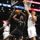 Brooklyn Nets' Joe Johnson (7) shoots between Los Angeles Clippers' Jamal Crawford (11) and Ryan Hollins (15) in the first half of an NBA basketball game on Friday, Nov. 23, 2012, at Barclays Center in New York. (AP Photo/Kathy Kmonicek)