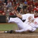 Cincinnati Reds' Scott Rolen slides safely into home plate scoring the go-ahead run after a Todd Frazier ground out to Pittsburgh Pirates relief pitcher Jared Hughes in the eighth inning during a baseball game, Saturday, Aug. 4, 2012, in Cincinnati. The Reds won 5-4. (AP Photo/David Kohl)