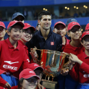 Novak Djokovic of Serbia holds his trophy and poses with ball boys after winning the Men's singles final match against Tomas Berdych of Czech Republic at the China Open tennis tournament at the National Tennis Stadium in Beijing, China, Sunday, Oct. 5, 2014. (AP Photo/Vincent Thian)