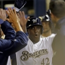 Milwaukee Brewers' Yuniesky Betancourt celebrates in the dugout after hitting a grand slam during the third inning of a baseball game against the San Francisco Giants on Tuesday, April 16, 2013, in Milwaukee. (AP Photo/Morry Gash)