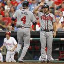 Atlanta Braves' Dan Uggla and Paul Janish (4) score against the Philadelphia Phillies in the second inning of a baseball game on Wednesday, Aug. 8, 2012, in Philadelphia. (AP Photo/H. Rumph Jr)