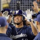 Milwaukee Brewers' Yovani Gallardo is congratulated by teammates after scoring on a single by Norichika Aoki during the sixth inning of their baseball game against the Los Angeles Dodgers, Wednesday, May 30, 2012, in Los Angeles.  (AP Photo/Mark J. Terrill)