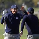 U.S. golfer Phil Mickelson (L) slaps hands with teammate Keegan Bradley after Bradley's approach shot to the 11th green during the morning foursomes round at the 39th Ryder Cup matches at the Medinah Country Club in Medinah, Illinois, September 29, 2012. REUTERS/Jeff Haynes