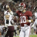 Alabama quarterback AJ McCarron (10) reacts after throwing a touchdown pass during the first half of an NCAA college football game at Bryant-Denny Stadium in Tuscaloosa, Ala., Saturday, Oct. 27, 2012. At left is Mississippi State linebacker Cameron Lawrence (10). (AP Photo/Dave Martin)